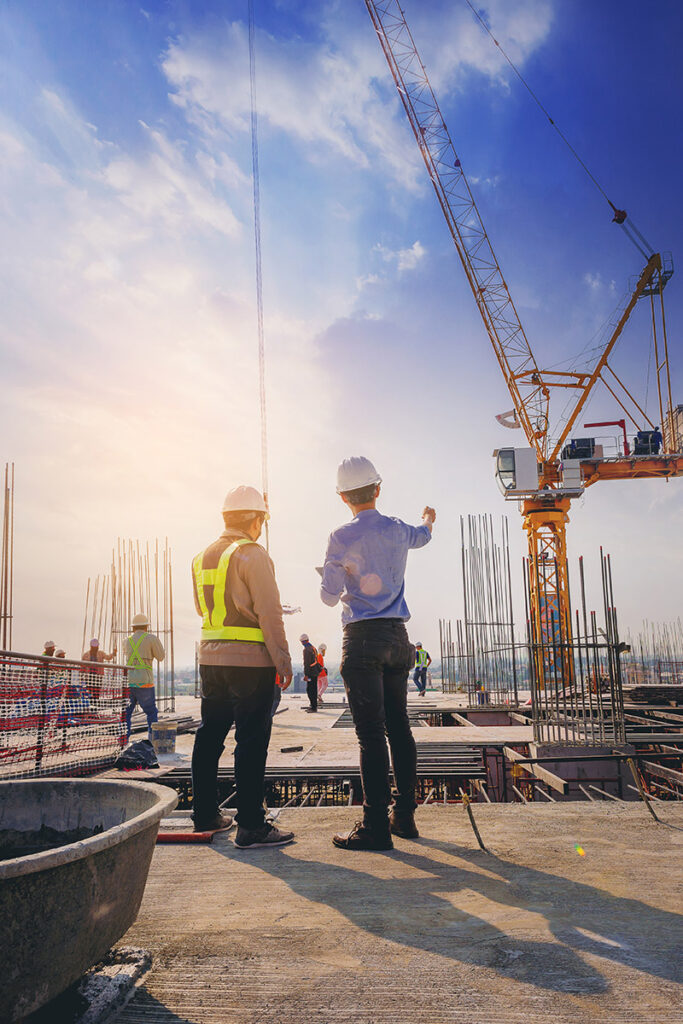 Two foremen on a construction site overlooking progress.