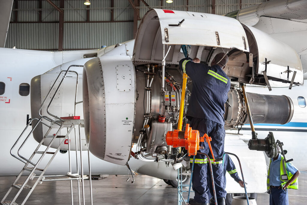 Workers performing maintenance on a plane engine.