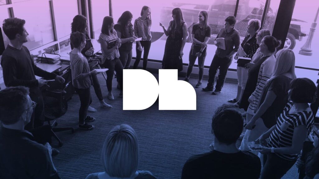 DH's logo imposed on a gradient photo of a group of people gathered in a circle having a discussion.