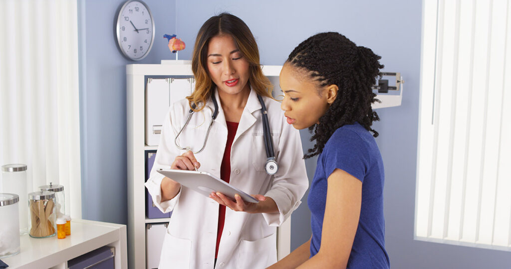 A doctor reviewing patient information with the patient in question.