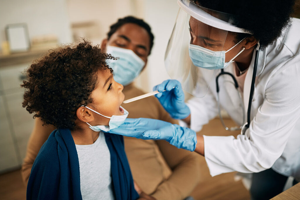 A female pediatrician working with a family for a checkup.