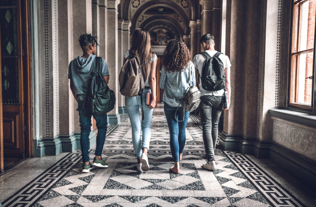 An image of university students walking down the marbled hall of their school.