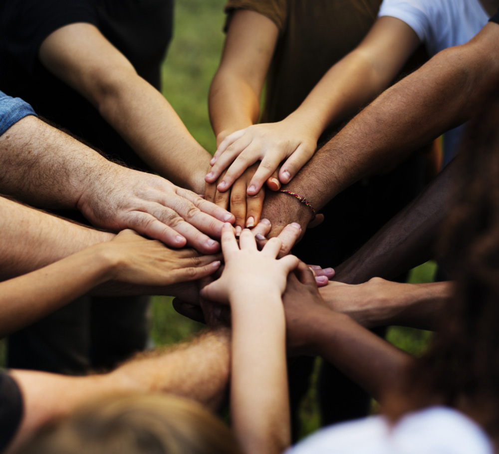 An image of hands coming together in a group pledge.