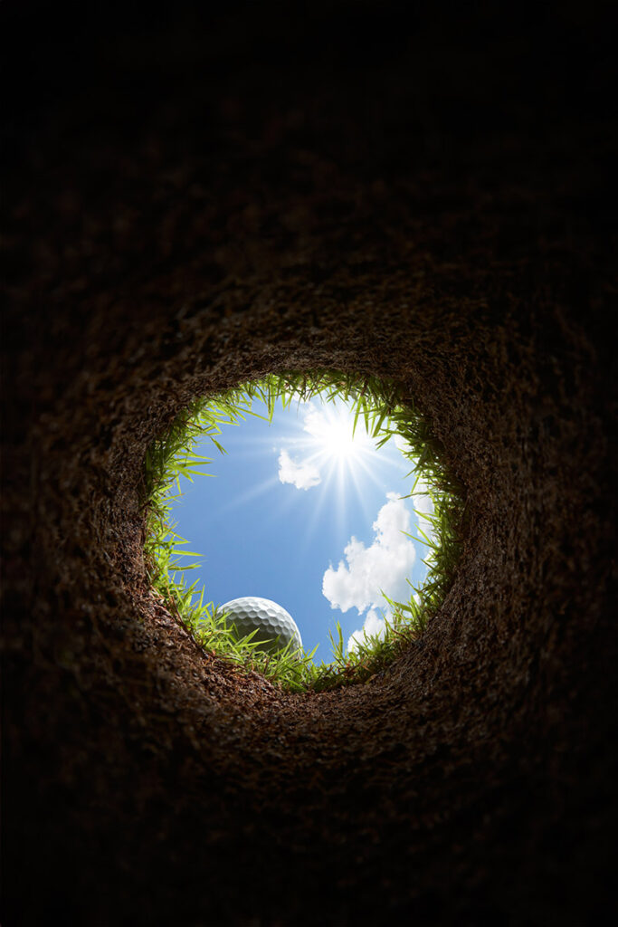 A golf ball as seen from below, inside the hole.