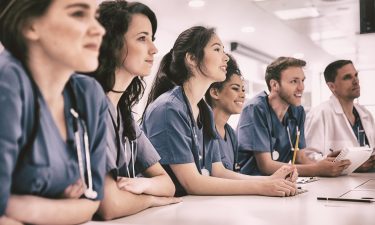 Medical students listening sitting at desk