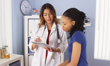 A doctor reviewing patient information with the patient in question.