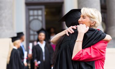 young female graduate hugging mother