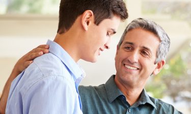 Father Helping Teenage Son Pack For College